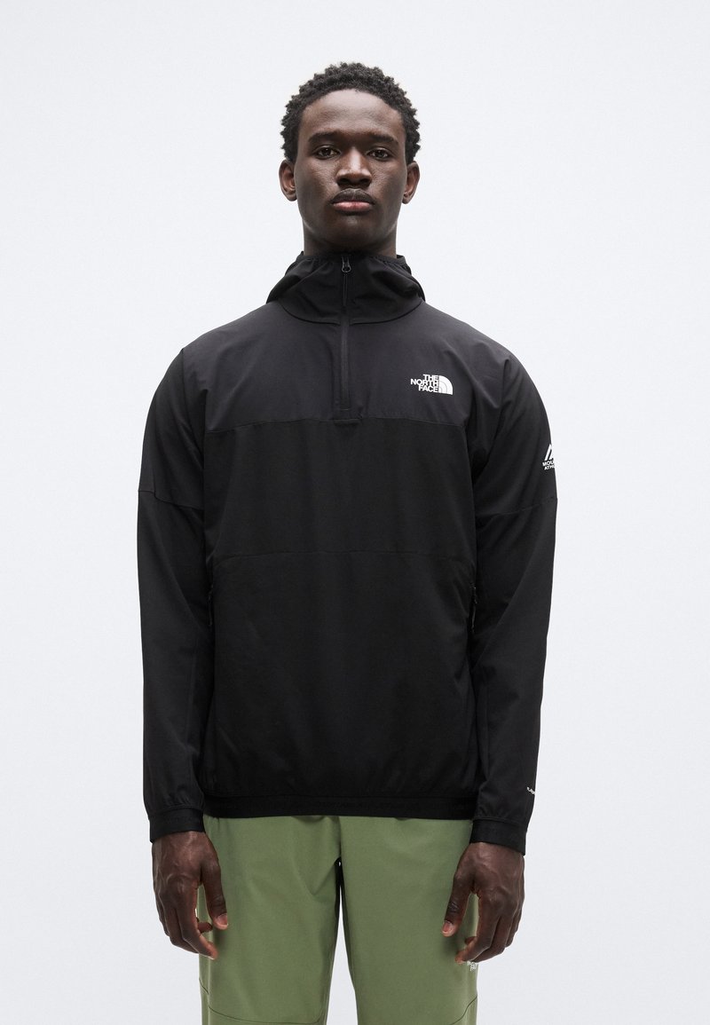 Μαύρο πουλόβερ με φερμουάρ μέχρι τη μέση στο γιακά, με λογότυπο στο στήθος και τα μανίκια, κατασκευασμένο από ελαφρύ, λείο υλικό.