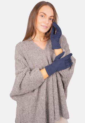 Navy blue gloves made of smooth material, fitted design with long cuffs, paired with a textured gray sweater.