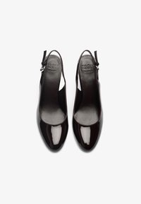 Μαύρες παπούτσια slingback από πατενταρισμένο δέρμα με στρογγυλή μύτη, λεία υφή και ρυθμιζόμενο λουρί. Έχει σήμανση ZIGN στο πέλμα.