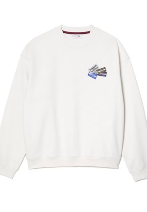 Sudadera blanca con escote redondo y puños de canalé. Presenta un parche impreso colorido en el pecho con varios diseños gráficos.