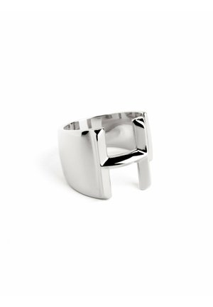 Sølv abstrakt ring med en glat tekstur, der har et unikt åbent design og rektangulære accenter på begge sider.