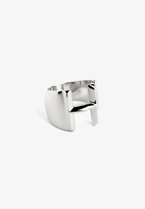 Sølv abstrakt ring med en glat tekstur, der har et unikt åbent design og rektangulære accenter på begge sider.