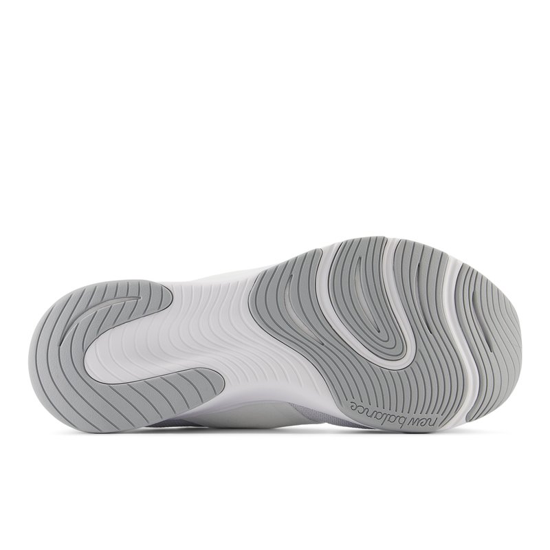 La suela del zapato presenta un diseño de goma gris con patrones en forma de olas, destacando las ranuras texturizadas y un borde blanco liso. El logo es prominente en el costado.