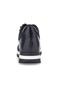 Sneaker in pelle nera con una texture liscia e lucida. Presenta una suola bianca e un design a caviglia bassa, con lacci e un dettaglio decorativo con cerniera.