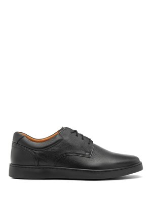 Chaussures en cuir noir avec une finition lisse, bout rond et coutures minimales. Dotées d'une semelle en caoutchouc profil bas et d'un revêtement intérieur beige.