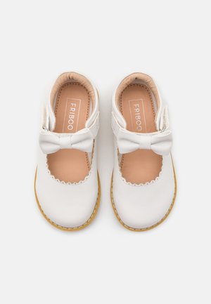 Weiße Lederschuhe mit gewelltem Rand, Schleifenakzent und beiger Innenausstattung. Gummisohle, entworfen für einen sicheren Sitz.