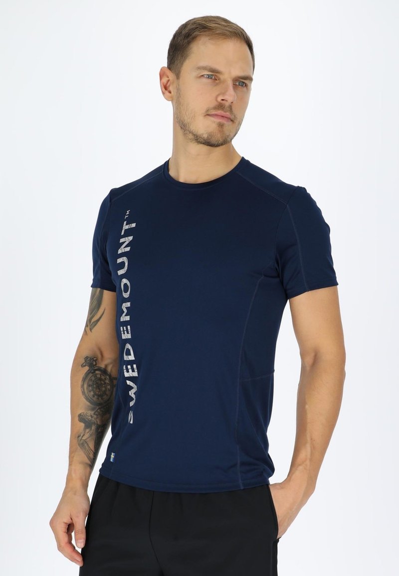 Marineblauwe sportshirt met een ronde hals, korte mouwen en een zilveren "SWEDEMOUNT" logo dat verticaal aan de linkerkant is gedrukt.