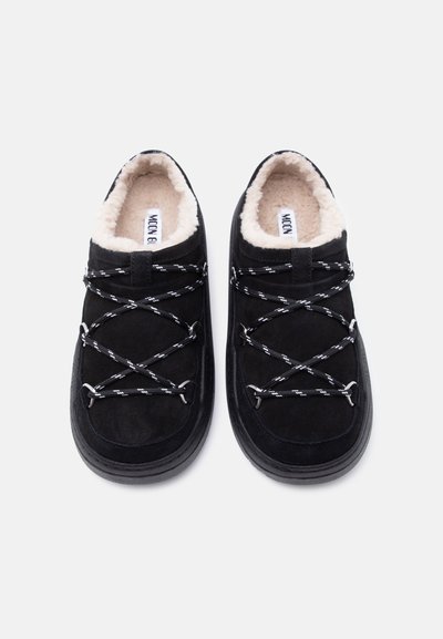 Μαύρα παπούτσια από σουέντ με λευκή επένδυση από μάλλινο ύφασμα, διαθέτουν διασταυρούμενα κορδόνια, στρογγυλερή μύτη και παχύ μαύρο καουτσούκ πέλμα.