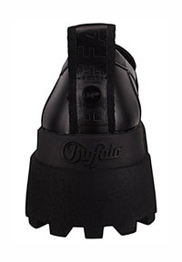 Sneaker platform nera con suola di gomma spessa, tomaia in pelle texturizzata e un distintivo tab sul tallone con il marchio "Buffalo".