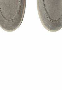 Zapatos de ante gris tipo slip-on con punteras redondeadas, que cuentan con costuras en contraste y una suela de goma de color claro. Textura suave, diseño minimalista.