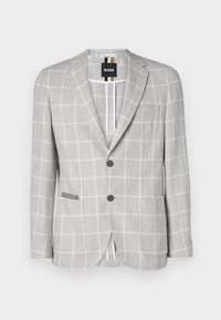 Lichtgrijze geruite blazer gemaakt van textuurstof. Beschikt over twee knopen, een zak en contrasterende details aan de binnenkant. Klassiek tailordesign.