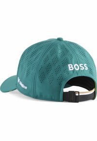 Turkisk cap med rund form, perforeret design og flad skygge. Har hvid branding "Boss" og "Valvoline." Justerbar sort rem bagpå.