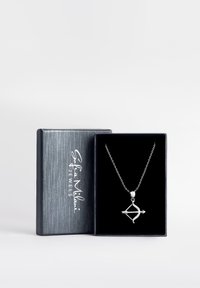 Silversmycke med en båge och pil-hänge med glittrande detaljer, presenterat i en svartsammetfodral med en metallisk silvrig utsida.