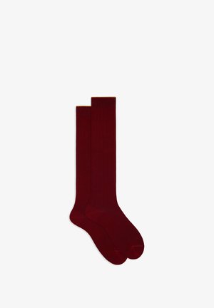 Burgundy ribbed knee-high socks with a contrasting golden cuff. Made from soft material, featuring a smooth texture and fitted shape.