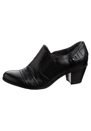 Musta nahkakenkä, jossa on korkea korko, joustavat sivupaneelit, pyöristetty varvas ja tikattu yksityiskohta. Korkeassa kantapäässä on hieno läpinäkyvä aksentti.