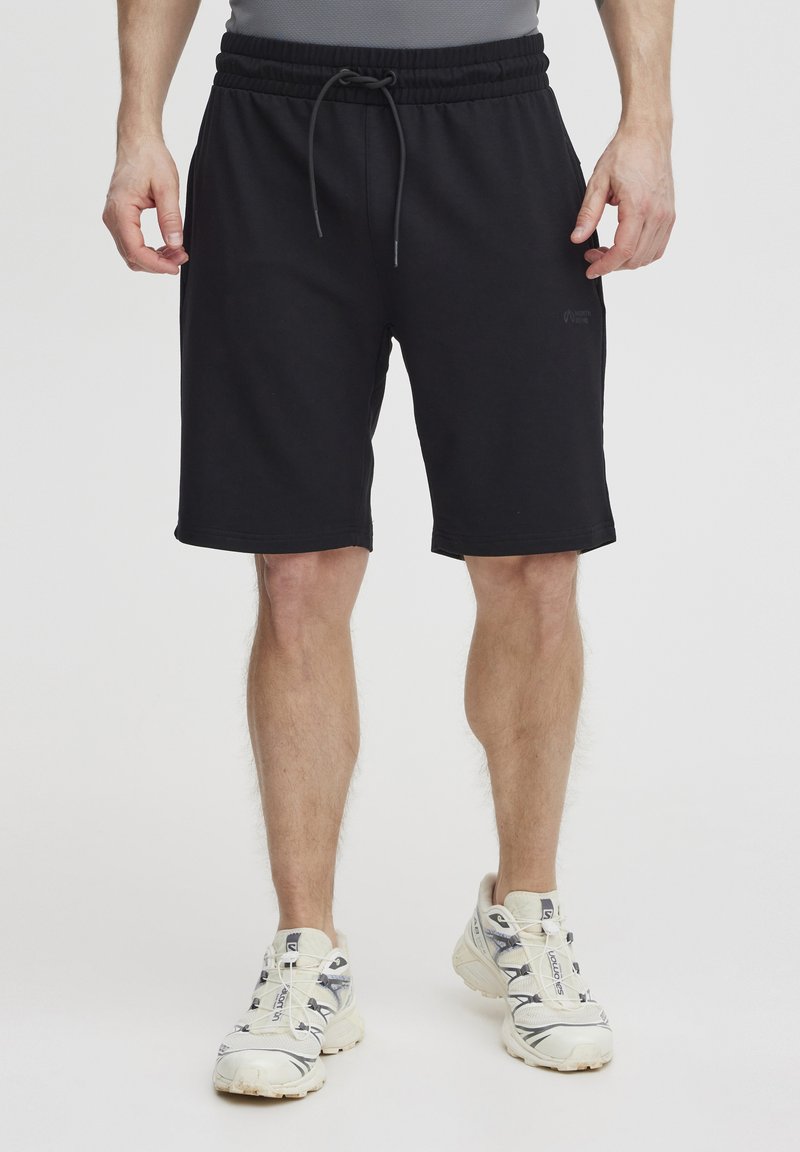 Schwarze Sportshorts aus weichem Material, mit einem elastischen Bund und Kordelzug, sowie einem dezenten Logo an der Seite.