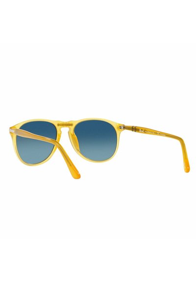 Occhiali da sole gialli trasparenti con lenti blu sfumate; forma arrotondata; aste sottili con finitura liscia e un sottile dettaglio del logo su un'asta.
