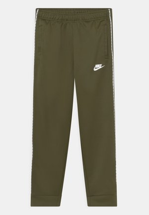 Olivengrønne Nike træningsbukser med elastisk talje, sidelommer, hvidt logo på venstre lår og hvide mærkede striber ned langs siderne.