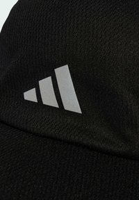 Gorra deportiva negra hecha de un tejido texturizado que presenta un logotipo reflectante de tres rayas en el frente.