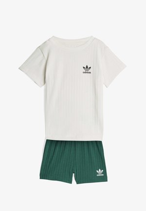 Biały prążkowany t-shirt z krótkim rękawem oraz ciemnozielone prążkowane szorty, oba z logo Adidas w kolorze czarno-białym z przodu.