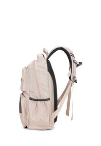 Sac à dos en tissu beige avec des accents noirs, plusieurs compartiments zippés, poches en mesh sur les côtés, bretelles ajustables et une forme structurée.