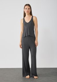 Charcoal gray loungewear set featuring a V-neck tank top with a relaxed fit and wide-leg, elastic waistband pants. Soft, lightweight fabric.