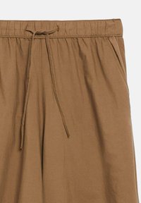 Brown elastic waist pants with front drawstring and side pockets, made from soft fabric.