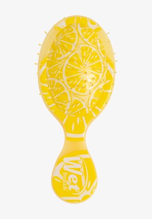 Brosse à cheveux jaune avec motif tranche de citron et poils jaunes aux extrémités, avec le logo « Wet brush » sur le manche.