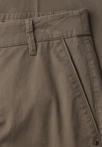 Bavlněné kalhoty v barvě taupe s poutky na pásek, úhlovou přední kapsou a viditelným detailem švu.