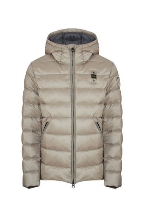 Giacca puffer trapuntata beige con cappuccio, zip frontale, tasche laterali con zip e piccoli patch logo neri e gialli sul petto e sulla manica.