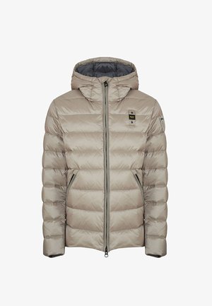 Giacca puffer trapuntata beige con cappuccio, zip frontale, tasche laterali con zip e piccoli patch logo neri e gialli sul petto e sulla manica.