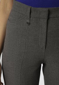 Gray trousers made of textured fabric, featuring a sleek design, smooth front, and a silver logo accent near the waistband.