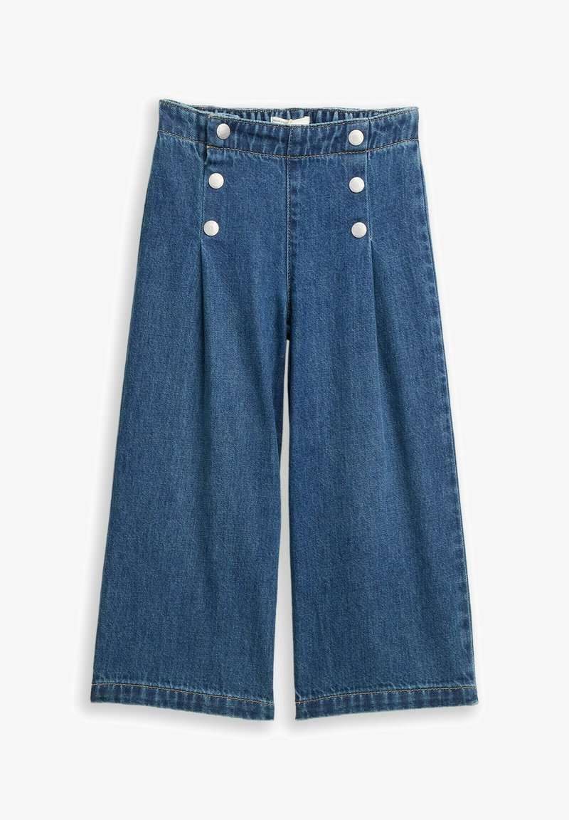 Pantalon en denim bleu à jambes larges, taille haute, avec deux rangées verticales de trois boutons blancs sur le devant.