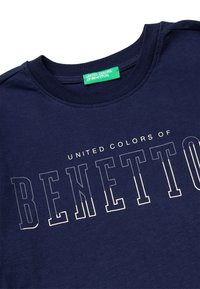 Tmavě modré bavlněné tričko s nápisem "UNITED COLORS OF BENETTON" v odvážném bílém písmu. Kulatý výstřih s hladkou texturou a zesíleným šitím.
