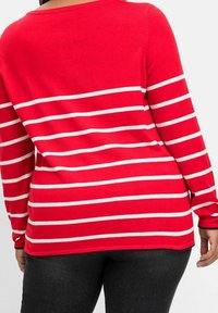 Roter Pullover mit weißen horizontalen Streifen, langen Ärmeln und rundem Ausschnitt. Rippbündchen und -saum verleihen dem Kleidungsstück eine Textur.