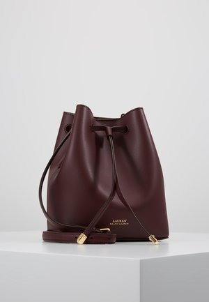 Sac seau en cuir bordeaux avec fermeture par cordon, bandoulière réglable et quincaillerie dorée embossée du logo "Lauren Ralph Lauren".