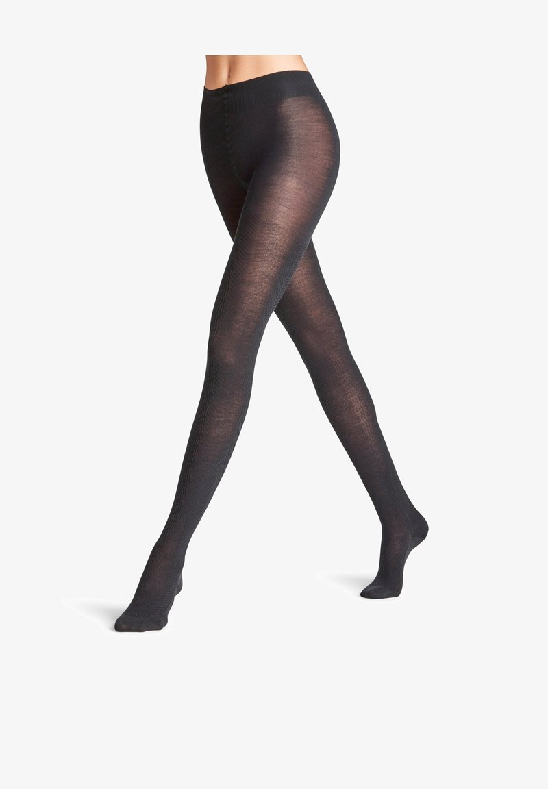 Collant neri opachi con una texture liscia, vita alta e dettagli a coste sottili. Modello con piedi che si estende fino al polpaccio.