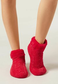 Røde ankel-lange slippers med et tekstureret strikdesign og en blød pelskant for ekstra varme og komfort.