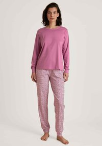 Lange mouwen roze top en gestreepte roze pyjamabroek met kleine witte bloemenpatronen, gemaakt van zachte, lichte stof.