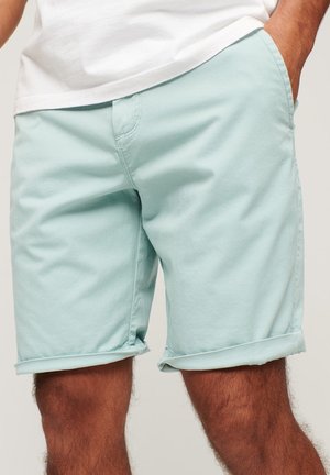 Shorts in cotone azzurro chiaro con una texture liscia, dotati di risvolti e tasche. La vita è leggermente elastica per un maggiore comfort.