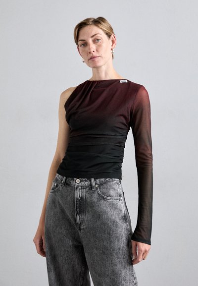 Top a maniche lunghe nero e bordeaux con dettagli drappeggiati, abbinato a jeans in denim grigi a vita alta. Tessuto trasparente su un braccio e silhouette aderente.
