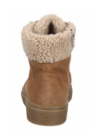 Hellbeige Wildleder-Stiefelette mit weichem beige-Fellfutter, seitlichem Reißverschluss und strukturierter brauner Sohle.