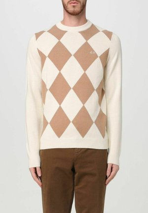 Maglione beige e crema con motivo argyle, colletto a girocollo e polsini a coste, abbinato a pantaloni marroni. Il materiale sembra morbido e lavorato a maglia.