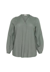 Blouse à pois verts avec un décolleté en V et des manches bouffantes, au toucher doux et à la coupe décontractée. Les pois varient en taille et en espacement.
