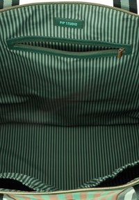 Green striped interior of a tote bag featuring a zip pocket and "PIP STUDIO" label. Fabric is smooth with contrasting dark and light green stripes.