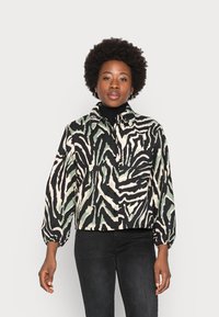 Casaco cropped em padrão zebra preto, verde e branco; apresenta colarinho de camisa e fechamento com botão; mangas longas e bufantes.