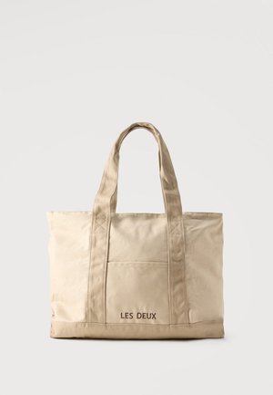 Borsa tote in tela beige con due manici e tasca frontale, con "LES DEUX" ricamato sulla tasca.