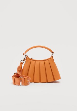 Orange pleated handbag with short handle and detachable wide fabric strap with metal clasps on a light background.