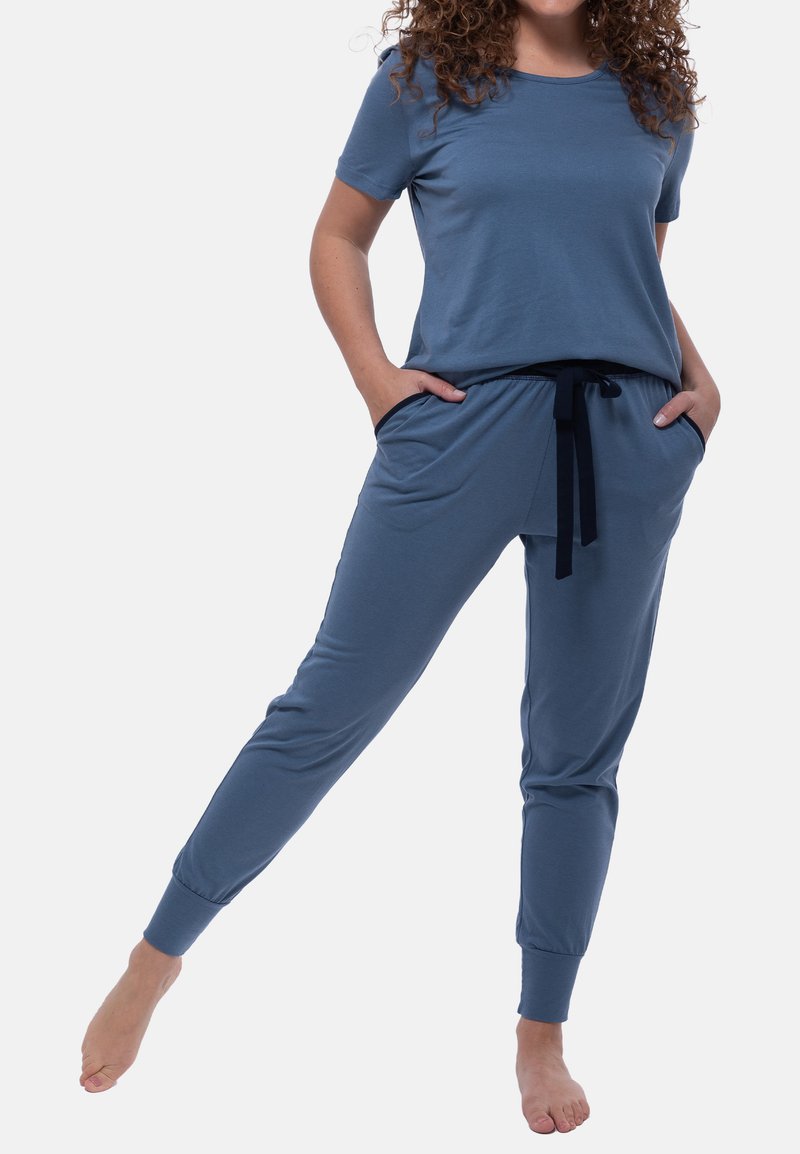 Sininen puuvillapaita ja verkkarihousut -setti, jossa on pyöreä kaula-aukko, lyhyet hihat, joustava vyötärö, sivutaskut ja kapenevat hihansuut.