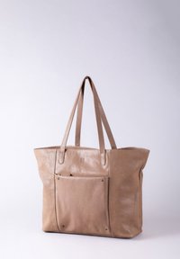 Beige leather tote bag with two long handles, a front pocket, and metal hardware accents. Smooth texture and structured shape.